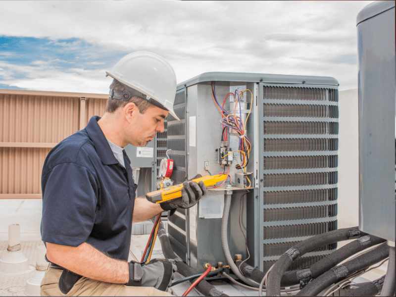 Technician performing routine maintenance on an HVAC unit to ensure reliable long-term heating and cooling.