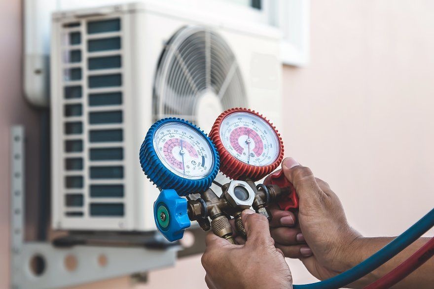 HVAC technician using diagnostic equipment to test refrigerant levels and electrical connections during a comprehensive system inspection 
