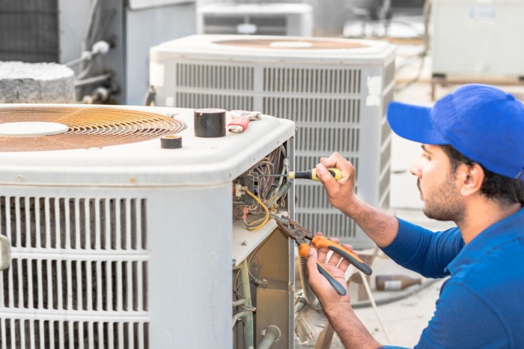 HVAC emergency technician repairing air conditioning system during summer heat wave
