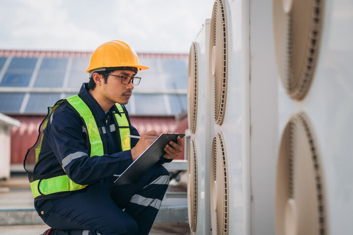 HVAC maintenance checklist on a clipboard with technician tools, including gauges, filters, and cleaning supplies in the background